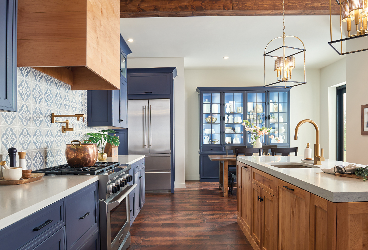 Trendy Navy Kitchen With Wood Textures, Tile Backsplash, and a Brushed Gold Faucet by Moen. Photo Courtesy of Moen.com
