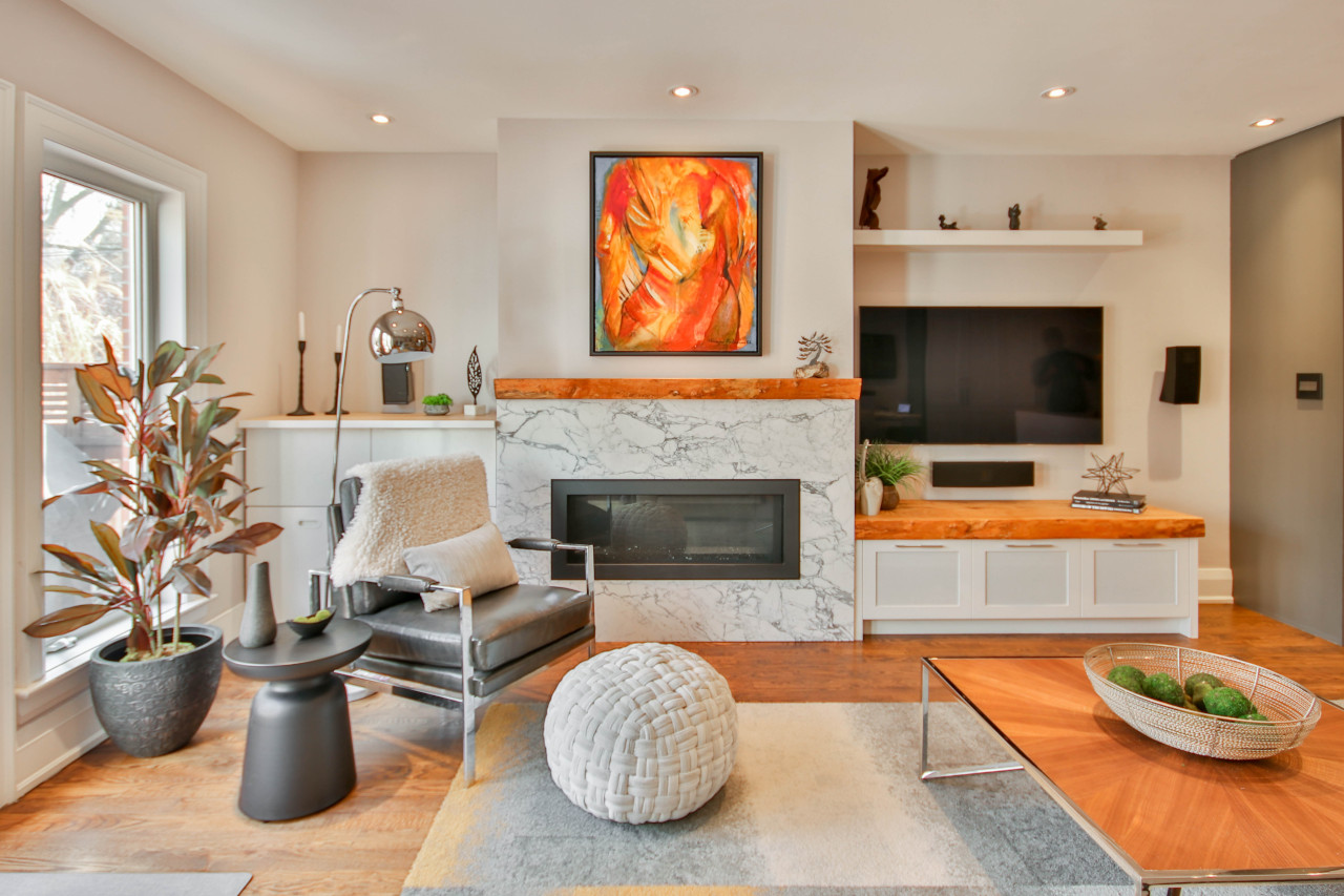 Gray, Black, and Wood Tones Living Room With Stone Fireplace Surround -- Photo Courtesy of Sidekix Media