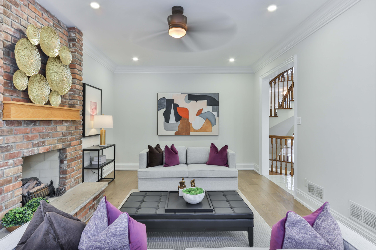 Contemporary Living Room With Abstract Expressionist Wall Art and Brick Fireplace -- Photo Courtesy of Sidekix Media