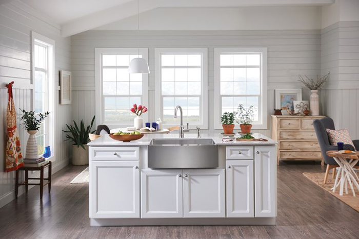 This comfortable farmhouse style kitchen includes an apron-front sink, wood-finish flooring and a single-lever faucet by Moen. Photo courtesy of Moen.com.