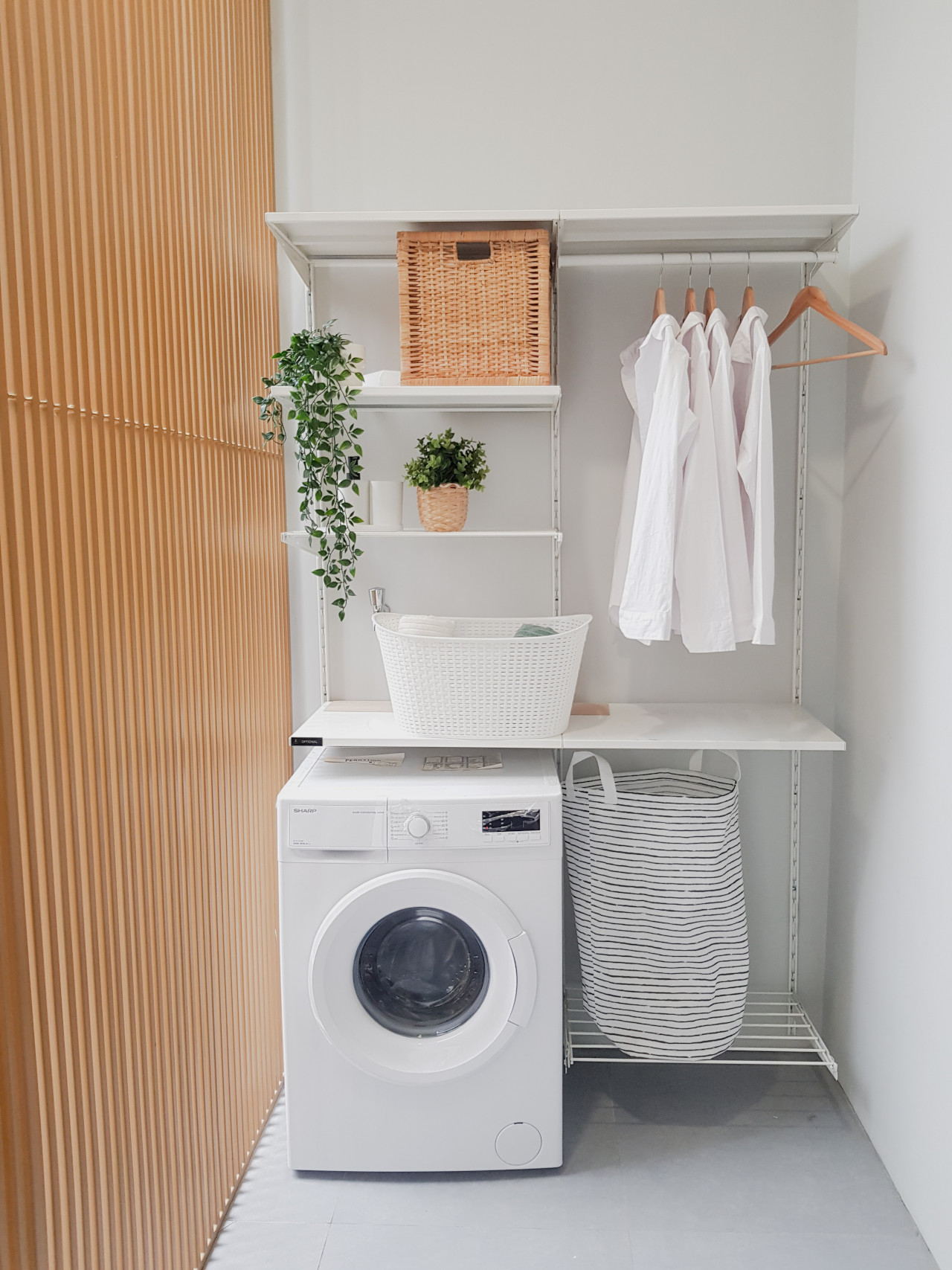 Room Divider, Baskets, Shelving and Clothes on Hangers in a Small Laundry Room